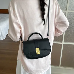 Vista posteriore dettagliata di una borsa a tracolla nera minimalista con chiusura dorata.