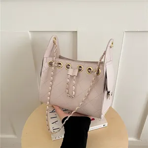 Detailed view of the pink quilted bucket bag with chain strap and elegant drawstring design.