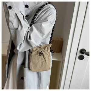 Detailansicht der lässigen minimalistischen Khaki-Umhängetasche mit stilvollem Seilriemen.