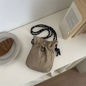 Detailansicht der minimalistischen Khaki Umhängetasche mit schwarz-weißem Kordelzug.