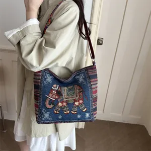 Ethische Segeltuch Umhängetasche mit traditioneller Elefantenstickerei und bunten Gurten.