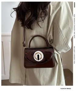 Elegante bolso bandolera de charol marrón con hebilla redonda, bolso de mano elegante chic.