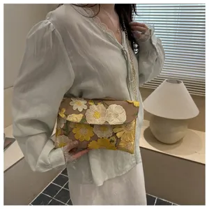 Detail view of women floral embroidered chain shoulder bag, elegant evening cloud bag.