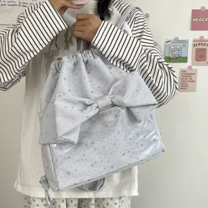 Dettaglio dello zaino con coulisse stampa stelle azzurro con grande fiocco e tasca trasparente.