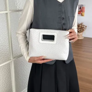 Vista dettagliata della elegante pochette texturizzata bianca con manico chic.