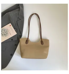 Chic khaki tote bag with brown straps displayed with blazer detail for daily commuting.
