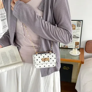 White polka dot crossbody bag with gold chain strap and metal lock for women daily wear