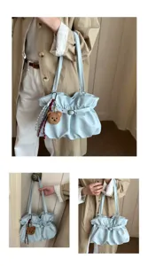 Detail view of light blue ruched shoulder bag, commuter tote featuring stylish belt buckle.