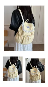 Vue détaillée d'un sac à dos en tissu jaune avec imprimé étoiles, dentelle et cordon de serrage.