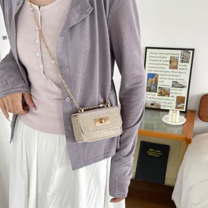 Stylish metallic texture crossbody chain bag with secure lock clasp, perfect summer accessory.