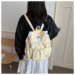 Vue détaillée du sac à dos jaune avec imprimé d'étoiles, bordure en dentelle et cordon.