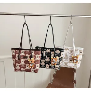 Vue détaillée de grands cabas imprimés d'ours mignons suspendus avec des pendentifs en peluche.