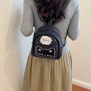 Cute black mini backpack with cat face design and star print for women and girls.