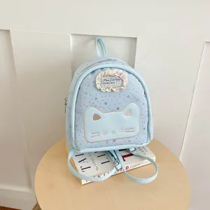Detailed view of cute light blue mini backpack with embroidered cat face and star patterns.