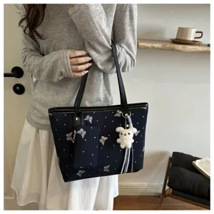 Stylish women shoulder tote bag with cute butterfly pattern and fluffy bear pendant detail.