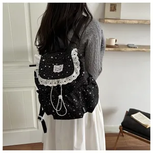 Sac à dos en toile imprimé étoiles noires avec jolie bordure en dentelle blanche.