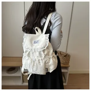 Vue détaillée du joli sac à dos blanc avec imprimé étoiles et bordure en dentelle.