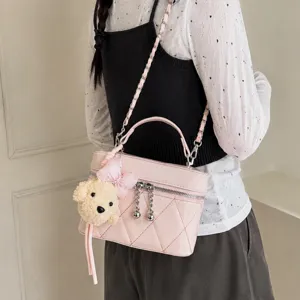 Pink quilted crossbody vanity bag with chain strap and cute plush bear charm for women.