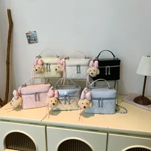 Detailed view of trendy quilted cosmetic crossbody shoulder bags with cute plush bear charms.