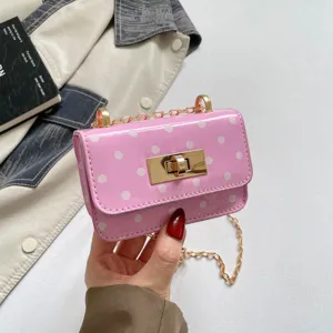 Pink patent leather polka dot mini shoulder bag detail showing gold chain and chic turn-lock closure.