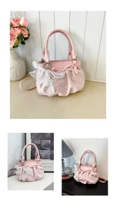 Dettaglio borsa a mano rosa a pois con grazioso fiocco di perle e design plissettato.