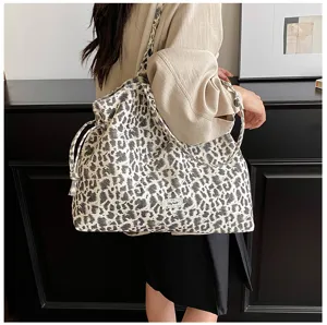 Detailed view of a stylish leopard print slouchy shoulder tote bag with drawstring.