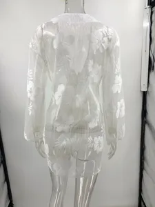 Gedetailleerd overzicht van witte bloemen mesh strandjurk met lange mouwen, transparante stof.