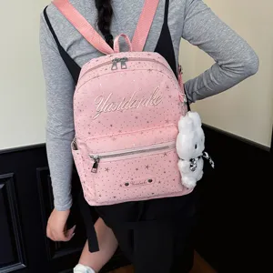 Pink star pattern backpack detail view, featuring fluffy bear pendant for college use.