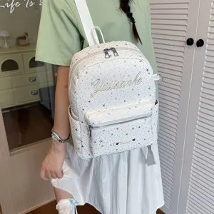 Detailed view of a stylish white star-patterned backpack worn by a model showcasing daily wear.