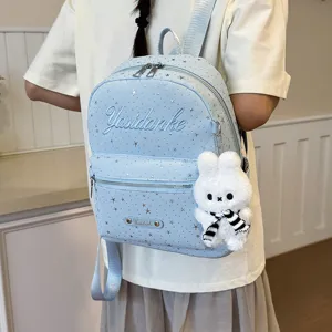 Light blue star pattern fashion backpack detailed view with cute rabbit pendant for daily commuting.