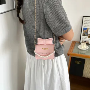 Detailaufnahme der rosa Kinder Umhängetasche mit süßer Perlen Schleife und goldener Kette.