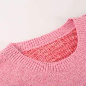 Roze gebreide truidetail met klassieke ronde halslijn en zachte textuurkwaliteit.