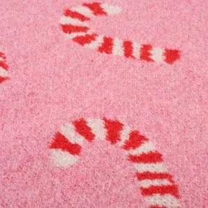 Close-up detail van de roze gebreide truien met feestelijke rood-witte zuurstokpatronen.
