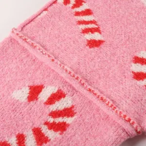 Close-up van de roze gebreide stof met rood-wit zuurstokmotief voor trui detail.
