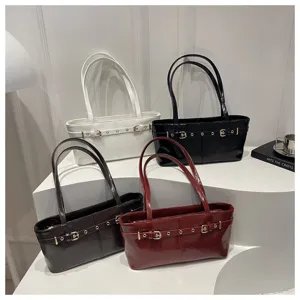 Detailed view of chic patent leather shoulder tote bags with stylish rivet belt designs.
