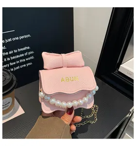 Joli sac bandoulière rose pour enfant avec nœud et perles tendance mode petite fille.