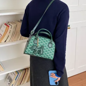 Green bowling bag detail view, stylish chevron pattern handbag with cute dog charm.