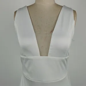 White deep V-neck sleeveless dress detail showcasing elegant bodice and high waist design.