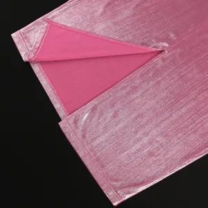 Close-up detail of pink metallic fabric and slit on women skirt, showing smooth texture.
