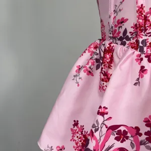 Detailansicht eines rosa blumigen trägerlosen Stufenkleides mit edlem Satin-Stoffdruck.