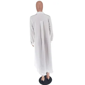 Detail view of the white long shirt showcasing eyelet grommet shoulder cutouts and loose hem.