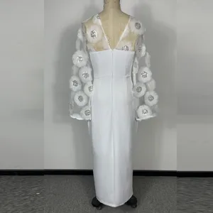 Gedetailleerd overzicht van een witte langere slim jurk met doorschijnende mesh mouwen en bloemen.