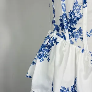 Nahaufnahme Detail des blauen Blumenkleides, Korsett-Stäbchen und Lagen-Peplum-Stoff.