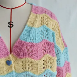Close-up view of the colorful wavy knitted cardigan sleeve and V-neck hollow-out detail.