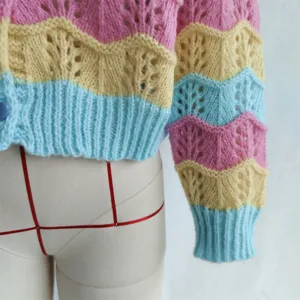 Close-up of colorful pastel chevron knit cardigan sleeve and textured hollow-out pattern.