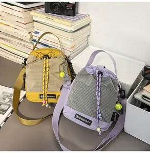 Casual canvas bucket shoulder bag with grid pattern and cute tennis racket keychain design.