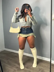 Women street fashion crop denim jacket and gradient skirt set with shoulder bag and boots.