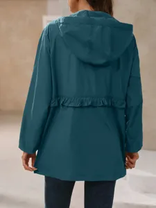 Detail view of a stylish women's hooded waterproof trench coat jacket in dark teal green.