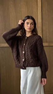Gedetailleerde close-up van het bruine vintage grove gebreide vest met mooie knopen.