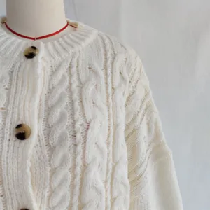 Gedetailleerd overzicht dames grof kabel gebreid vest, klassieke ronde hals en enkele rij knopen.